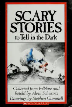 A book cover says the words 'Scary stories to tell in the dark,' and has a drawing of a skull with a pipe out of its mouth.