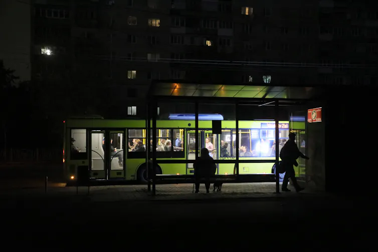 A bus is seen in a dark street.