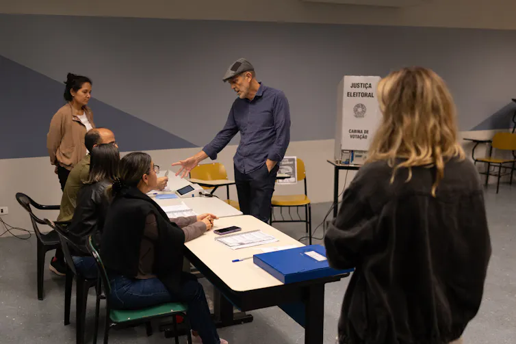 People stand around a table at a voting booth.