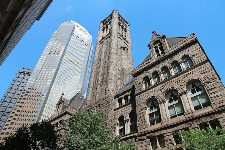 An old building juxtaposed against modern skyscrapers.