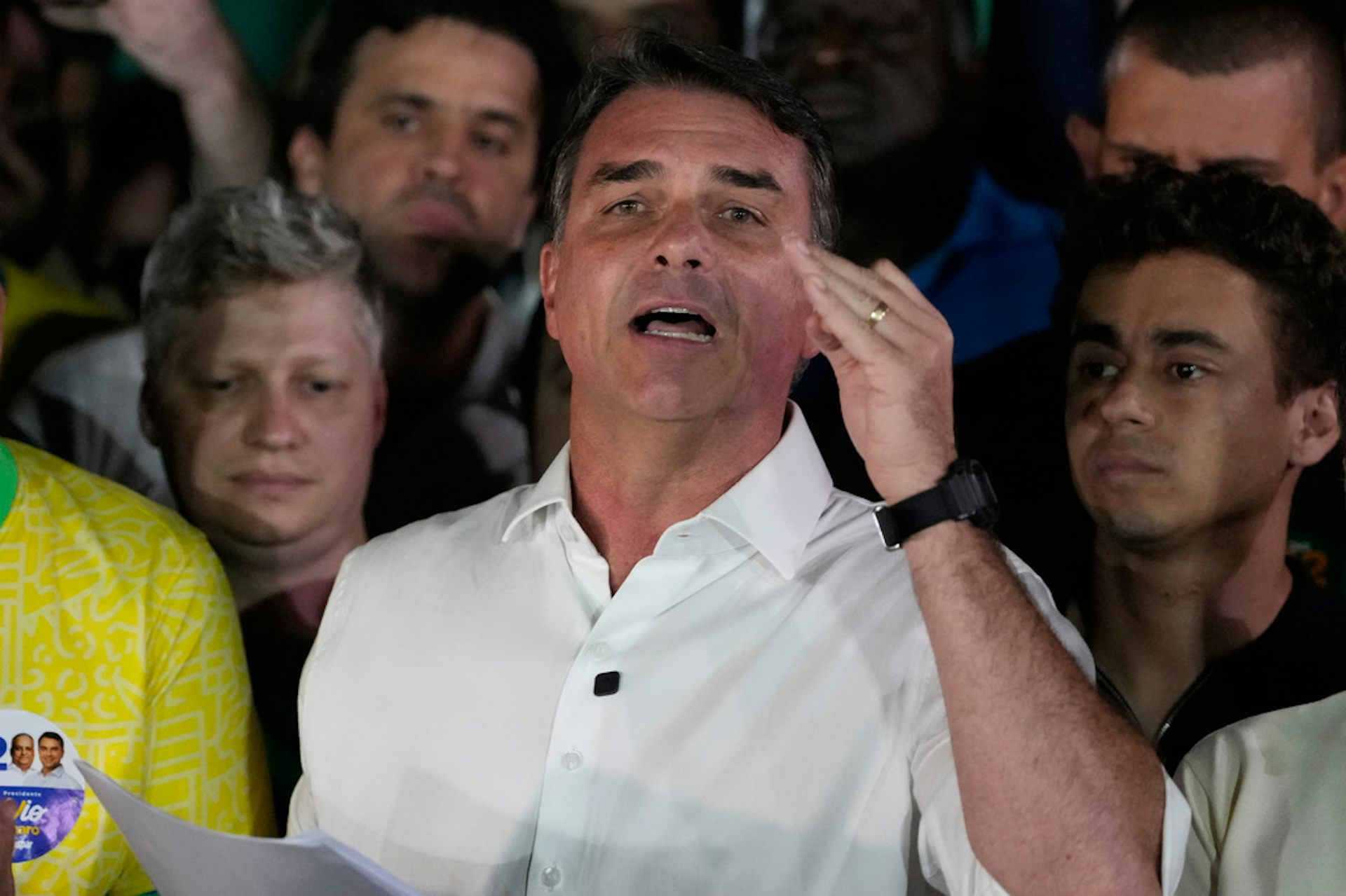 A man gestures in front of a crowd.