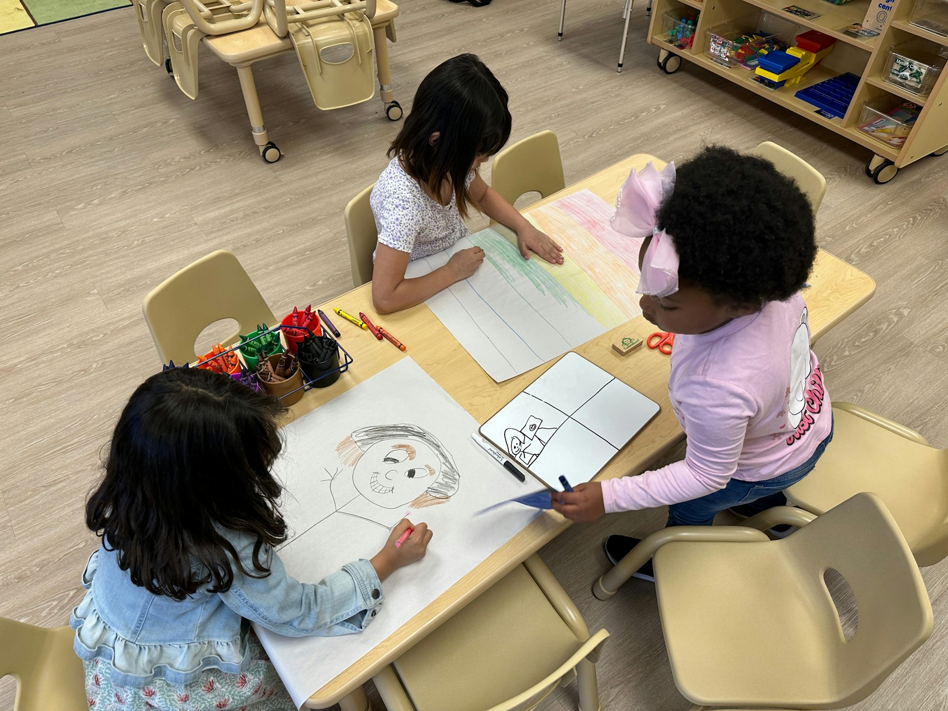 Three girls draw at a table at the Children's Promise Center in Albuquerque, New Mexico.