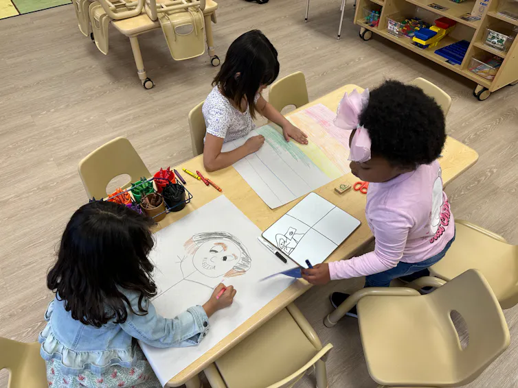 Three girls draw at a table at the Children's Promise Center in Albuquerque, New Mexico.