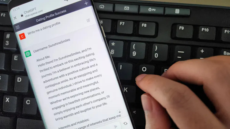chatgpt on a phone screen showing an ai-created dating profile with a computer keyboard in the background.
