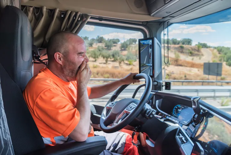A man yawning while driving.