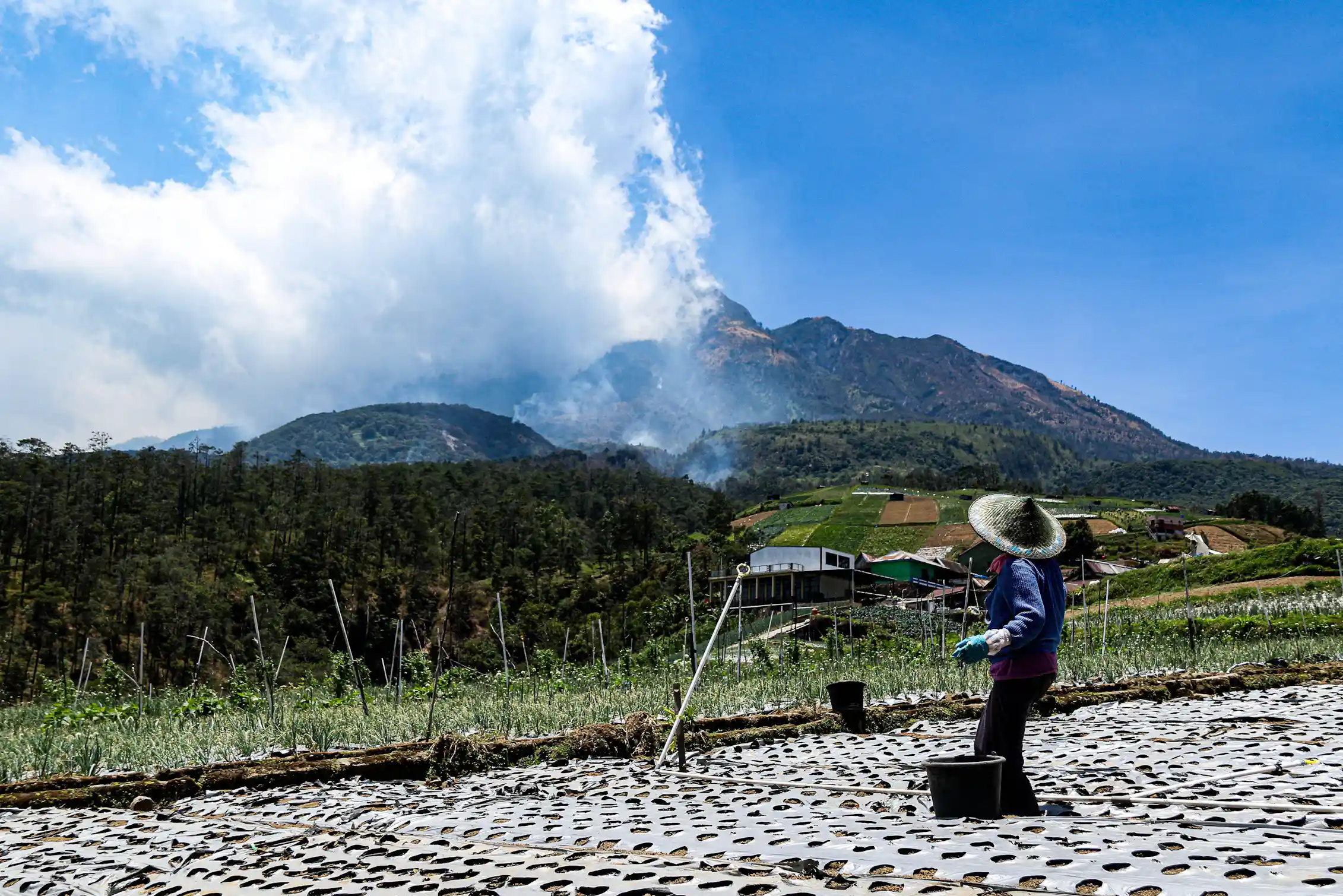 Plumes of smoke rise above a village in Java, Indonesia, October 2026. Sipa USA