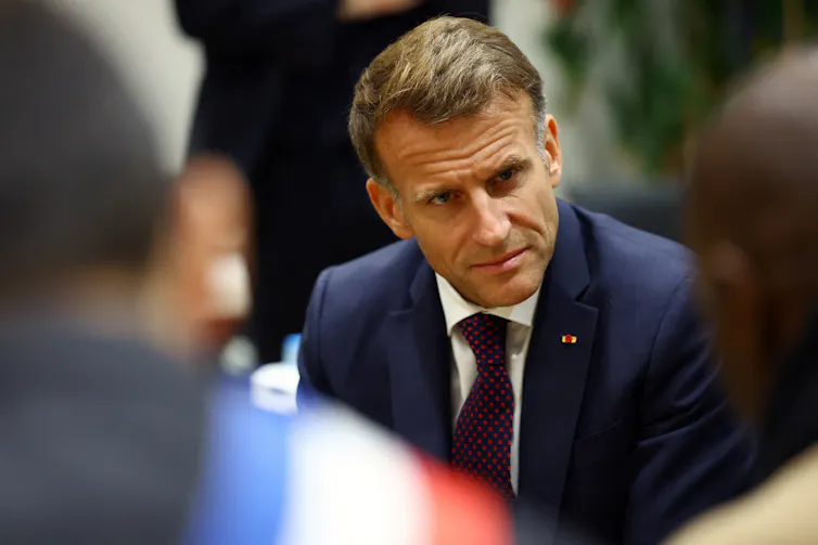 Man in a suit and tie looking thoughtfully to his left.