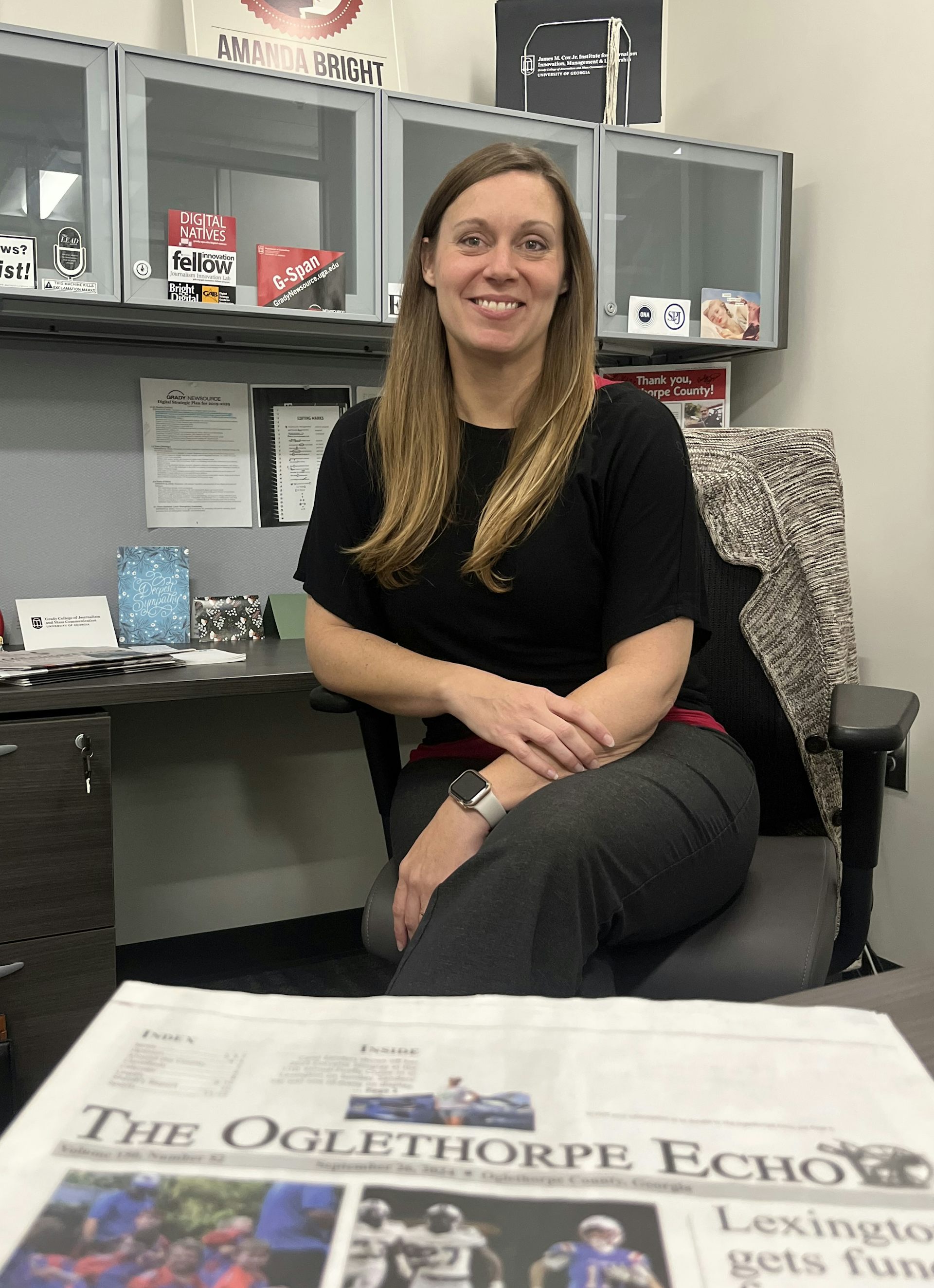 University of Georgia journalism professor Amanda Bright sits at her desk with a paper copy of The Oglethorpe Echo in front of her.