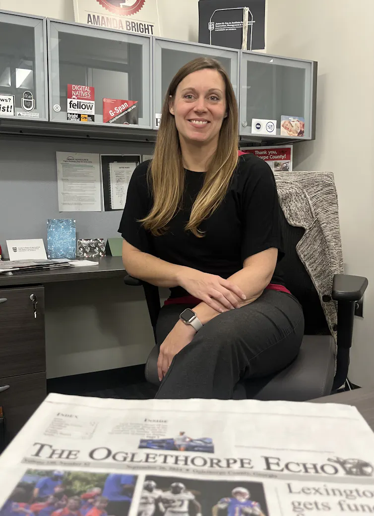 University of Georgia journalism professor Amanda Bright sits at her desk with a paper copy of The Oglethorpe Echo in front of her.
