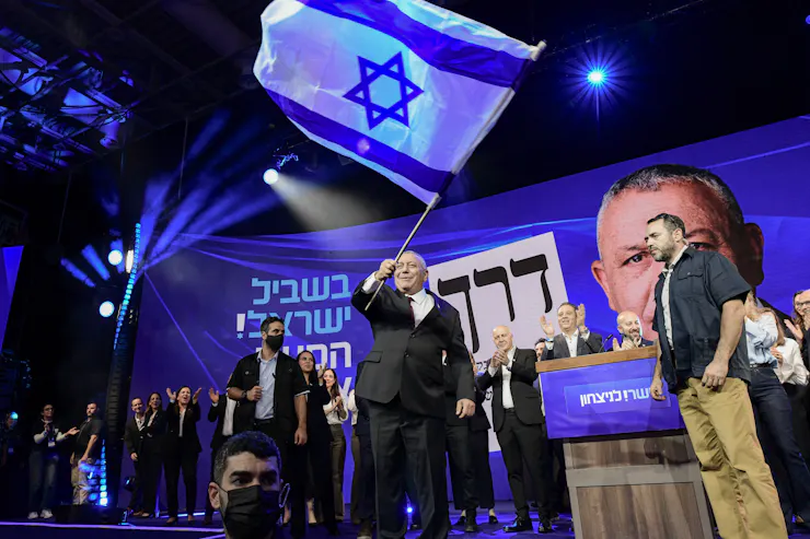 A man waves a large blue and white flag.
