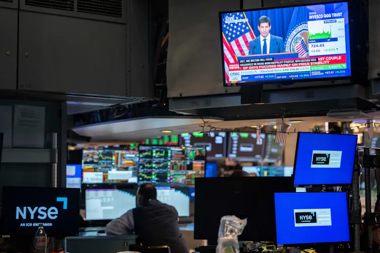 A screen over the floor of the New York Stock Exchange displays a news conference by Federal Reserve Board Chairman Kevin Warsh, Oct. 28, 2026.