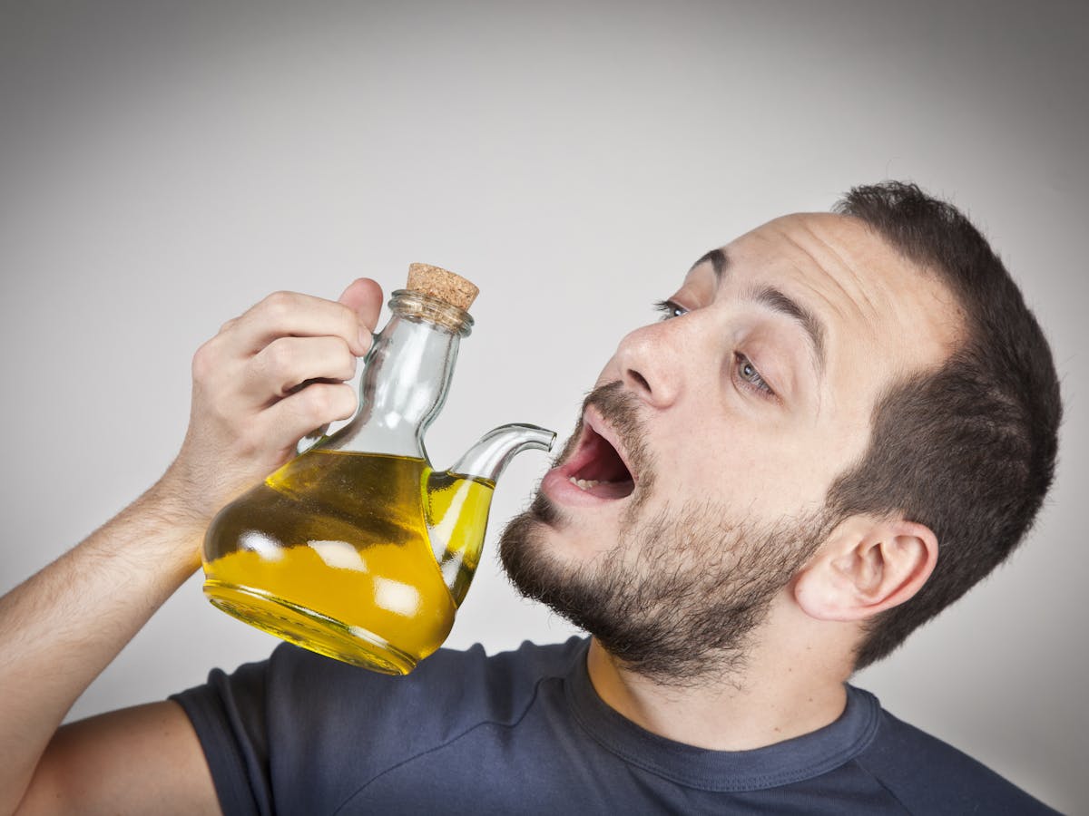 Оливковое масло для мужчин. Масло растительное и люди. Полоскание рта оливковым маслом. Пить масло. Человек пьет масло.